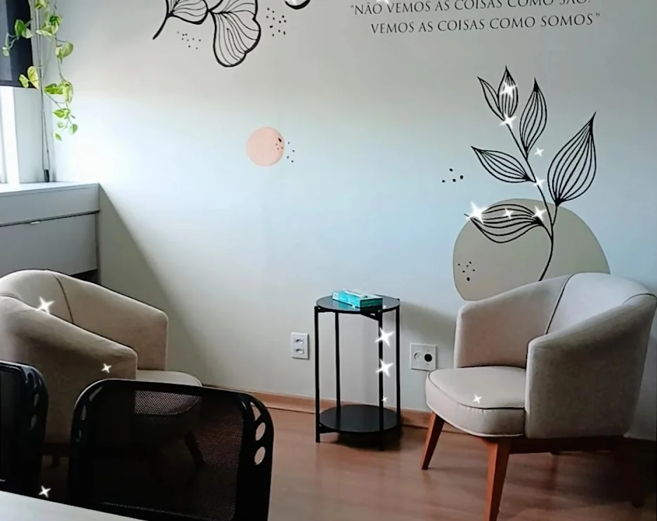 Canto do consultório com poltrona e a frase “não vemos as coisas como são, vemos as coisas como somos” na parede